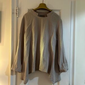 Light taupe colored top with graduated hem